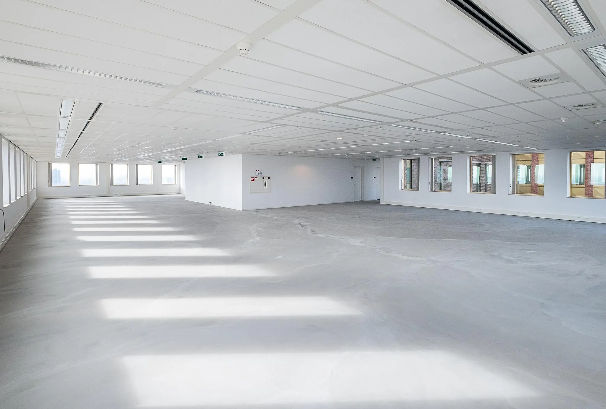 Leeg en licht modern kantoorinterieur aan de Fascinatio Boulevard met grote ramen en strak plafond.